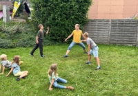 Kinder spielen auf der Wiese beim Museum
