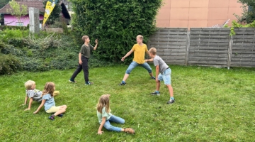 Kinder spielen auf der Wiese beim Museum
